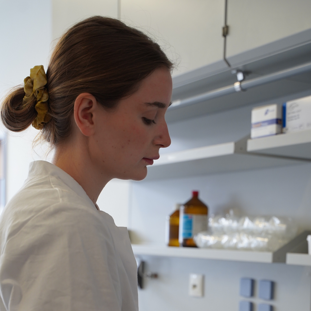 Eine Frau steht im Labor und produziert Make-up